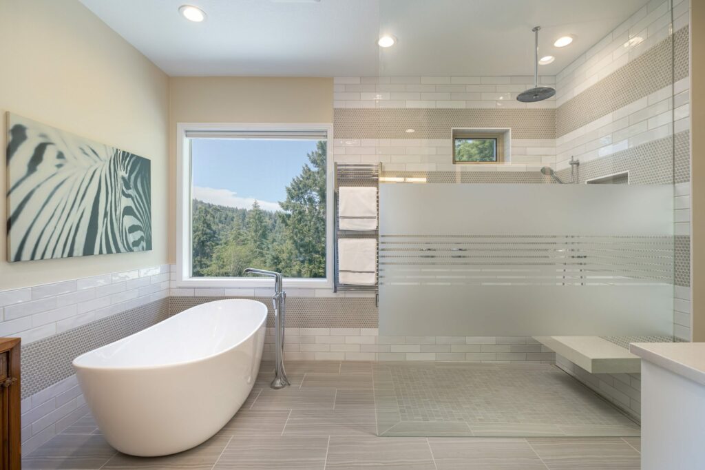 Luxury bathroom with freestanding tub in a large shower and big window to the outside to help illustrate How Long Does It Take to Remodel a Bathroom