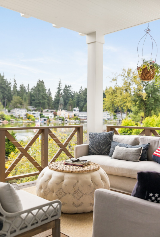 An outdoor living room space overlooking a lake