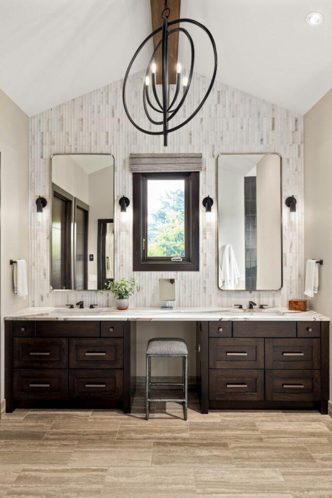 Baker 2024 b bathroom remodel with tall ceiling, double vanities, titled floor, and huge lighting fixture above.