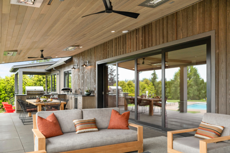 Luxury outdoor living space with ceiling fans and built in heating, kitchen, seating area, and dining area to help illustrate how to plan an outdoor living space.