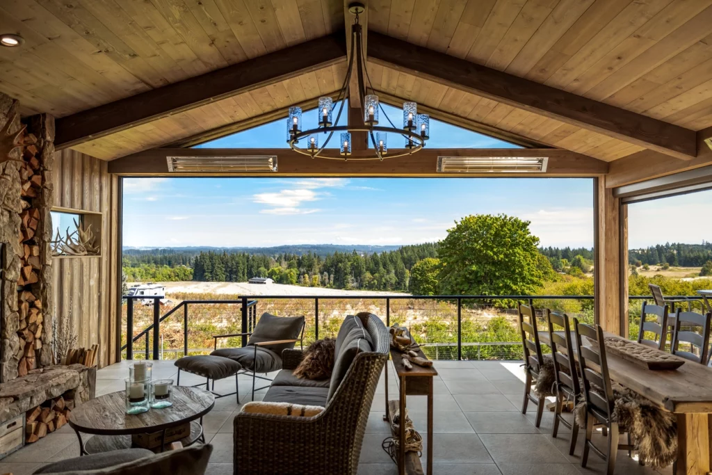 Outdoor living space including chandelier, fireplace, dining table, and sitting area to help illustrate hot to plan an outdoor living space.