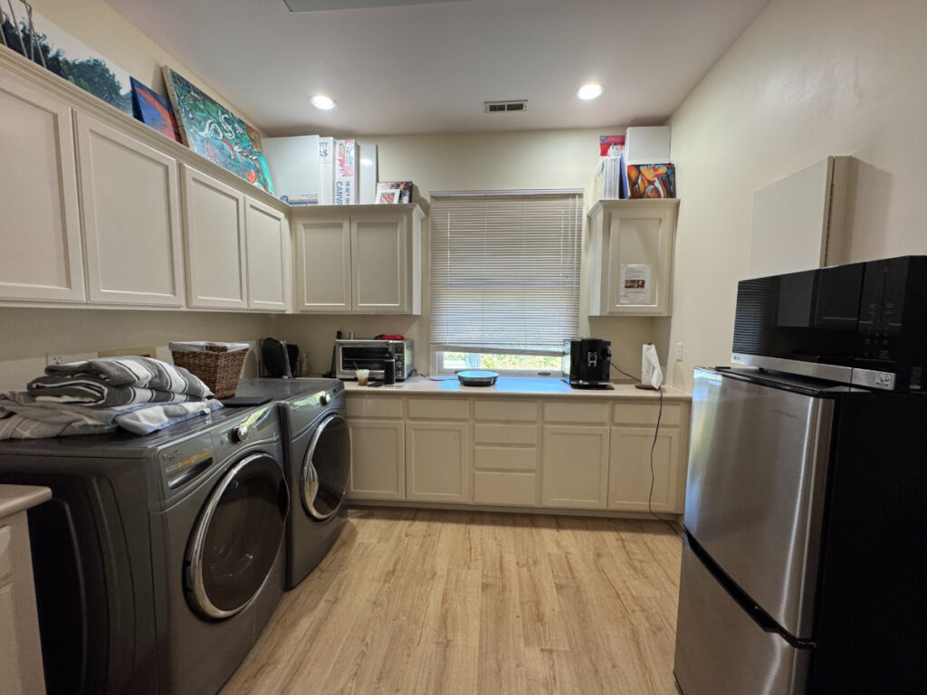 Temporary kitchen set up in a laundry room with a small fridge, coffeemaker, and microwave to help illustrate how to survive a kitchen remodel
