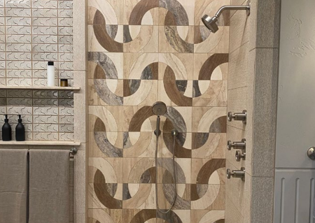 A bathroom featuring interesting tile designs in the shower and backsplash of sink.