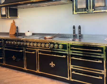 Black rang and oven with gold hardware and trim, including a few fleur-de-lis accents.